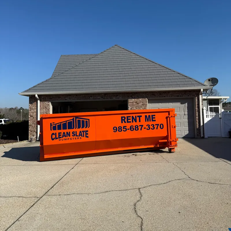 A Clean Slate Dumpsters orange roll-off on a Hammond residential driveway — typical placement for a homeowner project.