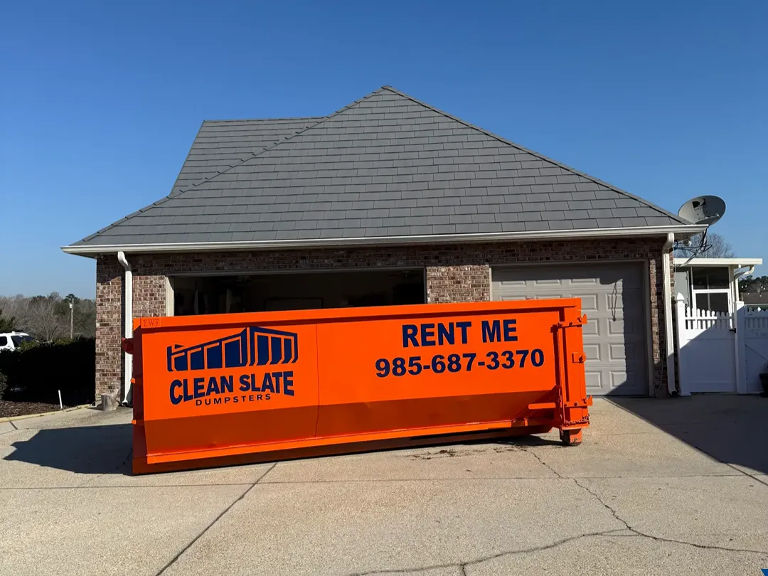 Orange dumpster rental in residential driveway