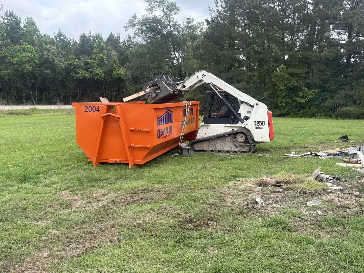 bobcat loading dumpster demolition site