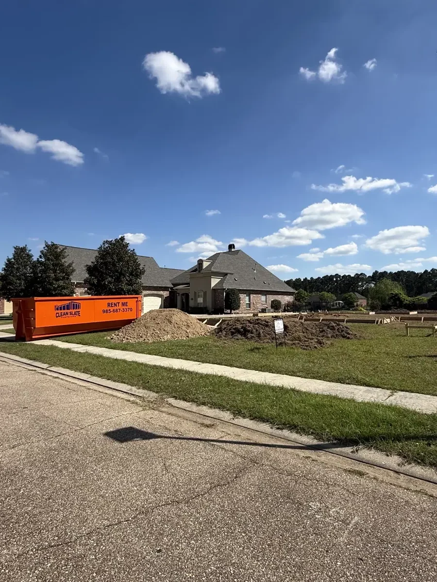 Orange Clean Slate Dumpsters roll-off container set on a residential driveway