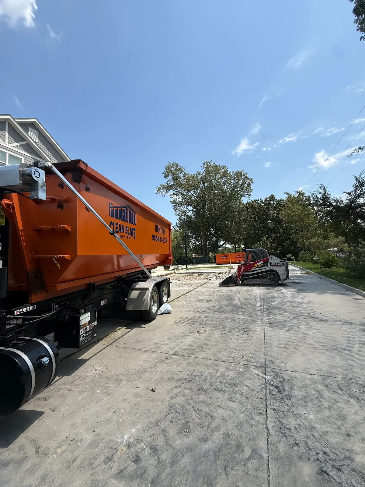 Clean Slate roll-off truck loading a container of concrete debris on a Hammond, LA job site